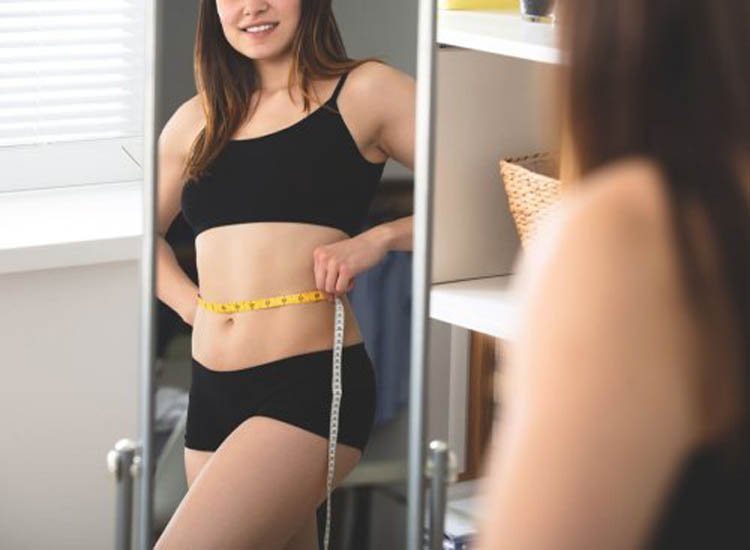 Woman measuring her waistline.