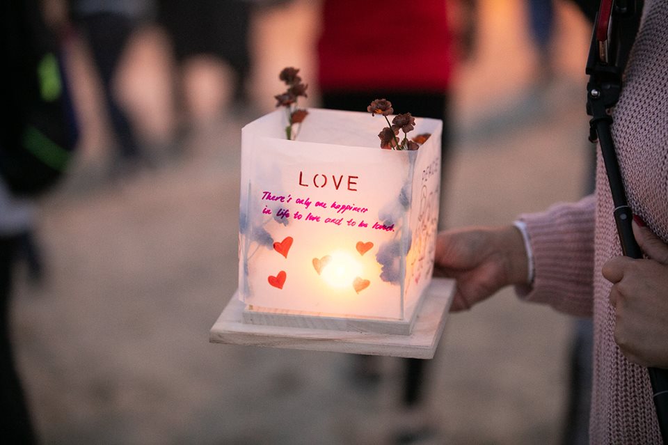 Person holding lantern with message on it, courtesy of Facebook 